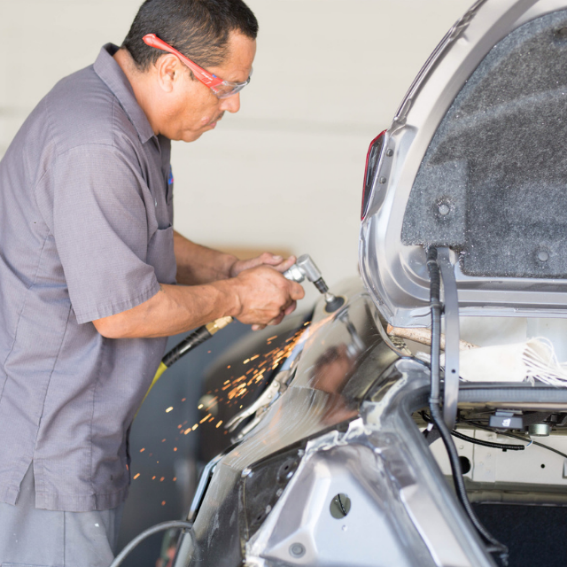 Auto body repair technician working on car trunk at Covina Auto Body.